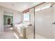 Contemporary bathroom showcasing a stylish tub, glass shower, and an outside view through a sizable window at 7812 Alola Springs Ln # Lot 1, North Las Vegas, NV 89084