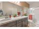 Modern bathroom featuring double vanity, quartz countertop, framed mirror, and glass-enclosed shower at 7812 Alola Springs Ln # Lot 1, North Las Vegas, NV 89084