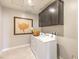 Well-lit laundry room features a white washer and dryer and stylish gray cabinets at 7812 Alola Springs Ln # Lot 1, North Las Vegas, NV 89084