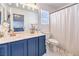 Bathroom with double sinks, blue cabinets, and shower at 7848 Desert Bell Ave, Las Vegas, NV 89128