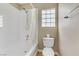 Bathroom featuring a tub and shower combo, a toilet, and a glass block window for privacy at 8235 Misty Sage St, Las Vegas, NV 89139