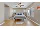 Bright bedroom featuring wood floors, a ceiling fan, natural light, and a cozy bed with blue pillows at 8235 Misty Sage St, Las Vegas, NV 89139