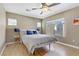 Bright bedroom featuring wood floors, a ceiling fan, natural light, and a cozy bed with blue pillows at 8235 Misty Sage St, Las Vegas, NV 89139