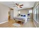 Bright bedroom featuring wood floors, a ceiling fan, natural light, and a cozy bed with blue pillows at 8235 Misty Sage St, Las Vegas, NV 89139