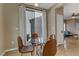 Bright dining area with a glass table, four chairs, and sliding doors to the backyard at 8235 Misty Sage St, Las Vegas, NV 89139