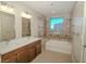 Bright bathroom with double sinks, a soaking tub, and natural light at 8255 Las Vegas Blvd # 415, Las Vegas, NV 89123