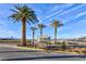 Community entrance signage amidst landscaped grounds, palm trees, and clear blue skies at 8255 Las Vegas Blvd # 415, Las Vegas, NV 89123