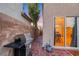 Cozy back patio features brick pavers, a stainless steel grill, and a view through the sliding glass door to the home's interior at 9151 Mount Wilson St, Las Vegas, NV 89113