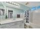 Bright bathroom featuring a white vanity, large mirror, and a shower-tub combination at 9151 Mount Wilson St, Las Vegas, NV 89113