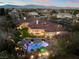 A dusk aerial view of the home and property, complete with pool, covered patio and well maintained landscaping at 9825 Glenrock Dr, Las Vegas, NV 89134