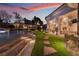 Dusk view of backyard features an illuminated stone walkway, lush lawn and covered patio at 9825 Glenrock Dr, Las Vegas, NV 89134