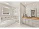 Bright bathroom featuring a tiled bathtub and shower, vanity area, and neutral color scheme at 9825 Glenrock Dr, Las Vegas, NV 89134