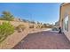 Expansive gravel backyard includes a patio, offering a private and serene outdoor experience at 1484 Midnight Cowboy Ct, Las Vegas, NV 89110