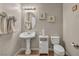 Charming half bathroom with pedestal sink, decorative mirror, sconce lighting and decorative artwork at 1484 Midnight Cowboy Ct, Las Vegas, NV 89110