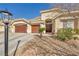 Inviting front entrance to the house with three-car garage and desert landscaping at 1484 Midnight Cowboy Ct, Las Vegas, NV 89110