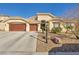 Charming home with a three-car garage and desert landscaping in front yard at 1484 Midnight Cowboy Ct, Las Vegas, NV 89110