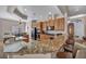Open kitchen with a granite countertop island, bar stool seating, and wooden cabinetry at 1484 Midnight Cowboy Ct, Las Vegas, NV 89110
