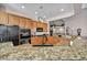 An angled view of the kitchen featuring a granite countertop island and a large, black refrigerator at 1484 Midnight Cowboy Ct, Las Vegas, NV 89110