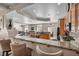 Spacious kitchen featuring wooden cabinetry, black appliances and seating at a granite countertop island at 1484 Midnight Cowboy Ct, Las Vegas, NV 89110