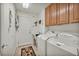Functional laundry room featuring a washer, dryer, storage cabinets, and a utility sink at 1484 Midnight Cowboy Ct, Las Vegas, NV 89110