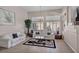Comfortable living room featuring elegant sofas, large windows, and neutral color tones at 1484 Midnight Cowboy Ct, Las Vegas, NV 89110