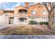 Shot of the building's exterior showing orange stucco and a mature shade tree at 220 Mission Catalina Ln # 202, Las Vegas, NV 89107