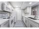 Modern kitchen featuring white appliances, quartz countertops, grey cabinets and wood-look laminate flooring at 220 Mission Catalina Ln # 202, Las Vegas, NV 89107