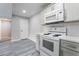 Modern kitchen featuring white appliances, quartz countertops, grey cabinets and wood-look laminate flooring at 220 Mission Catalina Ln # 202, Las Vegas, NV 89107
