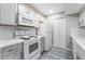 Modern kitchen featuring white appliances, quartz countertops, grey cabinets and wood-look laminate flooring at 220 Mission Catalina Ln # 202, Las Vegas, NV 89107