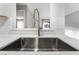 Close up of stainless steel kitchen sink with updated faucet and subway tile backsplash at 220 Mission Catalina Ln # 202, Las Vegas, NV 89107