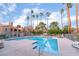 Community pool with lounge chairs and tall palm trees on a sunny day at 220 Mission Catalina Ln # 202, Las Vegas, NV 89107