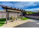 Relaxing backyard features a shaded pergola, outdoor seating and lush synthetic grass for low-maintenance enjoyment at 2210 Shadow Canyon Dr, Henderson, NV 89044