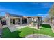 Private backyard with a covered patio, artificial turf, and a seating area perfect for relaxing at 2210 Shadow Canyon Dr, Henderson, NV 89044