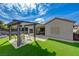 The backyard has a covered patio, an outdoor seating area, lush synthetic grass, and plenty of space for outdoor fun at 2210 Shadow Canyon Dr, Henderson, NV 89044