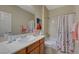 This full bathroom features a cherry vanity, large mirror and shower/tub combo at 2210 Shadow Canyon Dr, Henderson, NV 89044