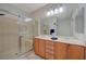 Bright bathroom featuring a double sink vanity, a large mirror, and a glass-enclosed shower at 2210 Shadow Canyon Dr, Henderson, NV 89044