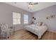This bright bedroom features wood-look floors, ceiling fan, and abundant natural light from two windows at 2210 Shadow Canyon Dr, Henderson, NV 89044