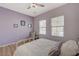 A well-lit bedroom features a modern ceiling fan, wood-look floors and light violet walls at 2210 Shadow Canyon Dr, Henderson, NV 89044