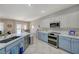 Stylish kitchen with modern stainless steel appliances, granite countertops, and two-tone blue and white cabinets at 2210 Shadow Canyon Dr, Henderson, NV 89044