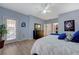 Cozy main bedroom with wood floors, neutral decor, a ceiling fan, and lots of natural light from the back patio at 2210 Shadow Canyon Dr, Henderson, NV 89044