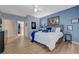 Comfortable main bedroom with blue walls, wood-look flooring, and ample natural light from the doorway to outside at 2210 Shadow Canyon Dr, Henderson, NV 89044