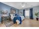 Serene main bedroom featuring a ceiling fan, blue accent wall, and soft natural light at 2210 Shadow Canyon Dr, Henderson, NV 89044