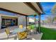 Relaxing covered patio with comfortable seating, lush synthetic grass, and an outdoor heater for year-round enjoyment at 2210 Shadow Canyon Dr, Henderson, NV 89044