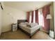 Bedroom with a gray upholstered bed frame, a bedside table, and bright natural light at 2412 Twin Flower Cir, Las Vegas, NV 89134