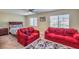 Comfortable bedroom features two red sofas, a cozy bed, and a ceiling fan with plush carpeting at 2865 Vigilante Ct, North Las Vegas, NV 89081