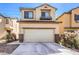 Two-story home featuring a two-car garage, neutral colors, and desert landscaping at 2865 Vigilante Ct, North Las Vegas, NV 89081