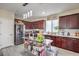 Well-lit kitchen featuring dark wood cabinetry, stainless steel appliances, and tile flooring at 2865 Vigilante Ct, North Las Vegas, NV 89081