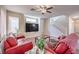 Spacious living room with staircase, red sofas, and large windows at 2865 Vigilante Ct, North Las Vegas, NV 89081
