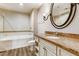 Clean bathroom featuring granite countertops, a bathtub, and an oval mirror at 30 Strada Di Villaggio # 143, Henderson, NV 89011