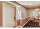 Hallway view with an apartment entrance and view of the exit, featuring patterned carpeting and warm lighting at 30 Strada Di Villaggio # 143, Henderson, NV 89011